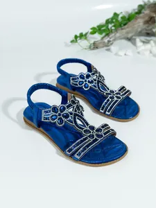 Detailed shot of blue Bohemian flat sandals with sparkling rhinestone flower designs