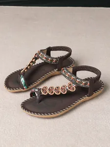 Detailed view of Bohemian sandals with intricate beaded floral patterns and ethnic straps