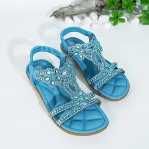 Elegant blue bohemian flat sandals featuring sparkling rhinestone flower decorations