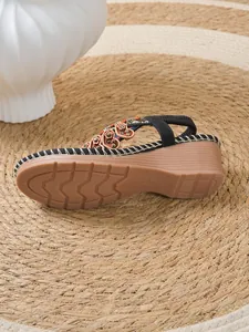Detail view showing the non-slip sole and heart charms on this bohemian wedge sandal