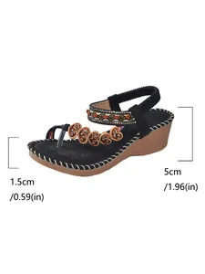 Bohemian wedge sandals with beaded heart charms and heel height dimension markings.