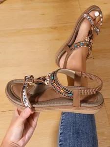 Detail view of bohemian flat sandals with handmade beads and ethnic embroidery straps.