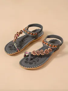 Detailed view of dark grey Bohemian sandals with colorful ethnic beads and floral accents