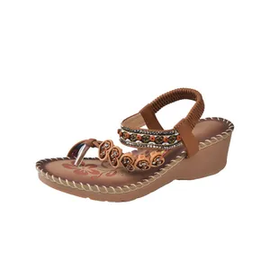 Bohemian brown wedge sandals with heart beads and elastic strap on white background
