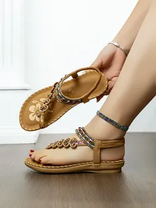 Detail of bohemian flat thong sandals featuring ethnic beads and floral decorations.