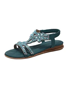Detailed view of bohemian teal flat sandals with intricate rhinestone and bead embellishments