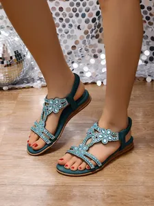 Bohemian turquoise flat sandals with intricate rhinestone and bead flower design.