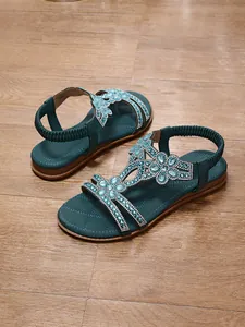 Detail of bohemian teal flat sandals with sparkling rhinestone and bead decorations
