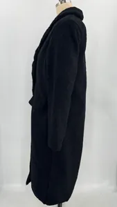 Side view detail of a black warm long fleece overcoat for women with lapel collar