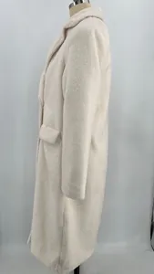 Detailed side view of a long cream-colored plush teddy coat with lapel collar on mannequin