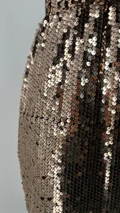 Detailed macro shot showing the texture of sparkly bronze sequins on a bodycon skirt