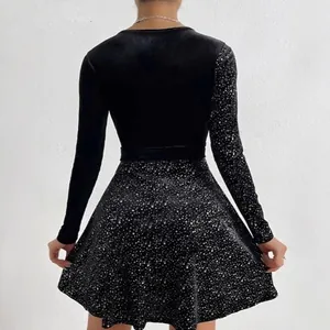 Close-up view of the back of an elegant black velvet dress with sparkling sequin skirt detail
