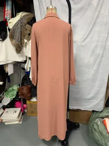 Back view detail of a long-sleeved coral pink loose shirt featuring a classic lapel collar
