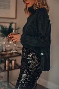 Elegant black sequin midi skirt with shimmering texture shown in a lifestyle setting
