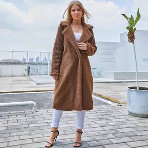 Outdoor full-body shot of a woman wearing a long brown teddy bear faux fur coat.