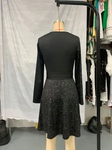 Rear view of an elegant black long-sleeved dress with sequin details on a mannequin.