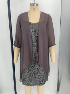 Close-up detail of an elegant two-piece lace dress with a sheer chiffon shrug on mannequin