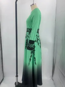Vista laterale di un vestito lungo sfumato verde e nero con stampa floreale su manichino