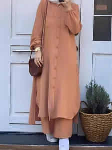 Elegant orange two-piece set featuring a long split shirt and wide-leg trousers.