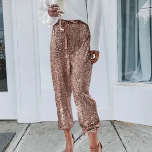 Detailed macro view of rose gold sequin texture on high-waisted casual jogger pants fabric