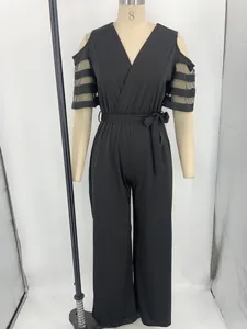 Elegante tuta nera con scollo a V, maniche in rete e cintura a vita alta regolabile.