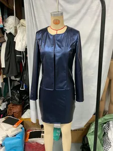 Detail shot of navy blue metallic shiny long sleeve jacket and matching mini skirt.