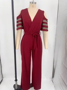 Dettaglio della tuta bordeaux con scollo a V e maniche in mesh su manichino