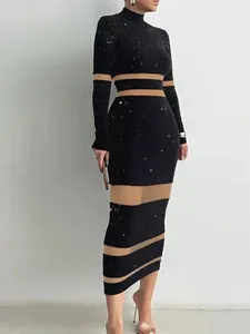 Elegante abito attillato nero a maniche lunghe con paillettes e strisce in mesh velato