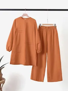 Completo due pezzi color terracotta con tunica a maniche lunghe e pantaloni larghi.