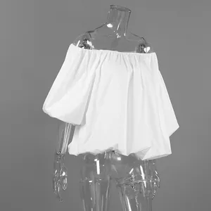 Detailed view of crisp white off-the-shoulder cotton blouse with voluminous puff sleeves.