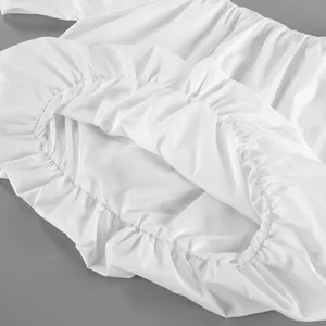 Detailed macro view of white cotton asymmetric off-shoulder blouse with ruffled texture