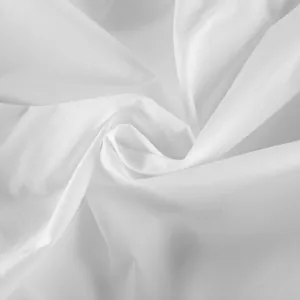 Detailed macro view showing the soft white cotton fabric texture of the asymmetric blouse