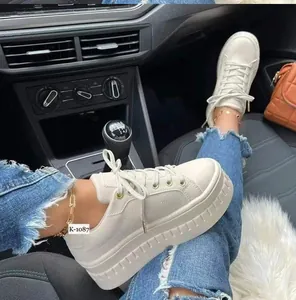 Close-up of stylish cream platform sneakers with thick soles and round toe in car interior