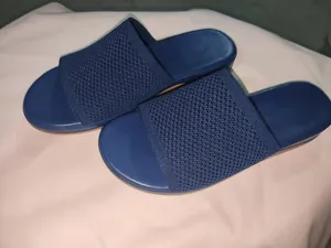 Close-up showing the navy blue knitted fabric texture on women's flat slide sandals
