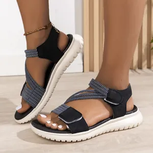 Close-up detail of sporty black sandals with criss-cross elastic straps and velcro