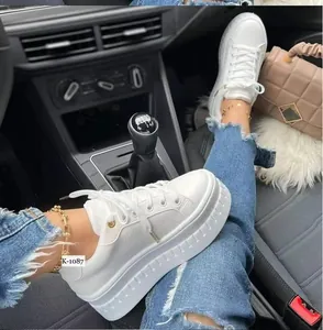 Close-up of women's white platform sneakers shown in a stylish car interior