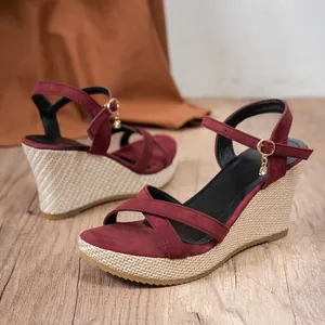 Side view of maroon suede wedge sandals with woven platform and ankle strap buckle