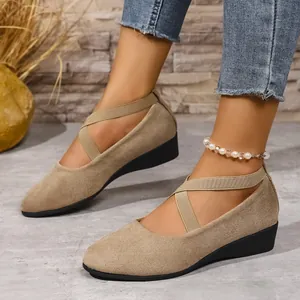 Primo piano di scarpe con zeppa color kaki da donna con cinturini incrociati elastici e punta tonda
