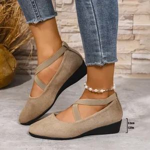 Vista laterale di scarpe con zeppa beige da donna con punta tonda e cinturini.
