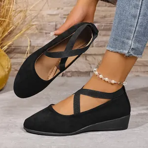 Vista dettagliata delle scarpe con zeppa nere a punta tonda con cinturini incrociati