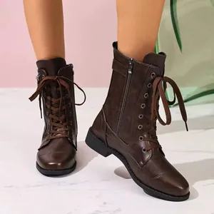 Close-up view of elegant brown lace-up combat boots with side zipper and chunky heel