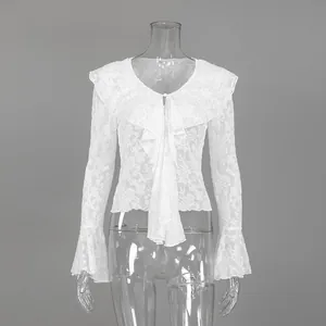 Dettaglio di camicia in pizzo bianco con volant francesi e maniche a campana eleganti