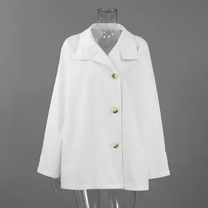 Detail of a white mid-length trench coat with large tortoiseshell buttons and lapel collar