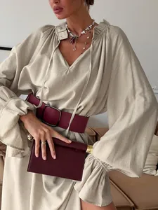 Detailed shot of a French design linen dress featuring a V-neckline and flared sleeves.