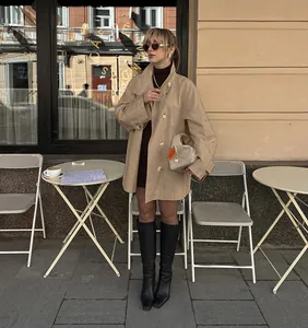 Outdoor lifestyle photo showing the elegant drape and fit of a khaki mid-length trench coat.