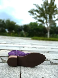 Macro detail of the anti-slip brown sole on a purple embroidered cowboy boot
