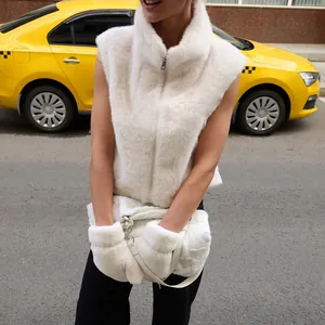 Close-up detail of a plush white faux fur vest featuring a high collar and zipper
