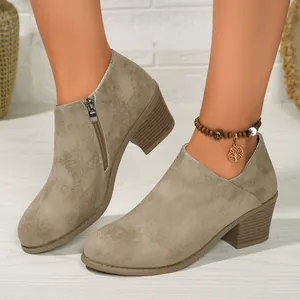 Close-up of women's khaki suede ankle boots with a comfortable chunky heel and side zipper.