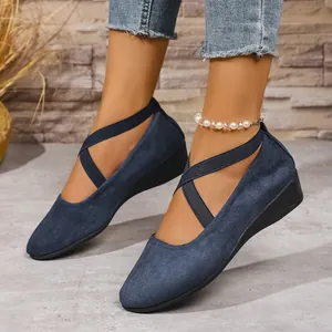 Vista laterale di scarpe blu con zeppa e cinturini elastici incrociati