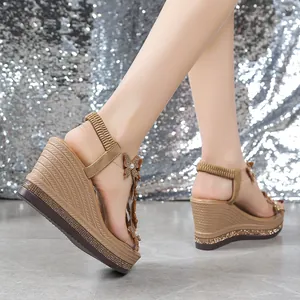 Detailed view of women's wedge sandals with sparkling rhinestone butterfly decorations.